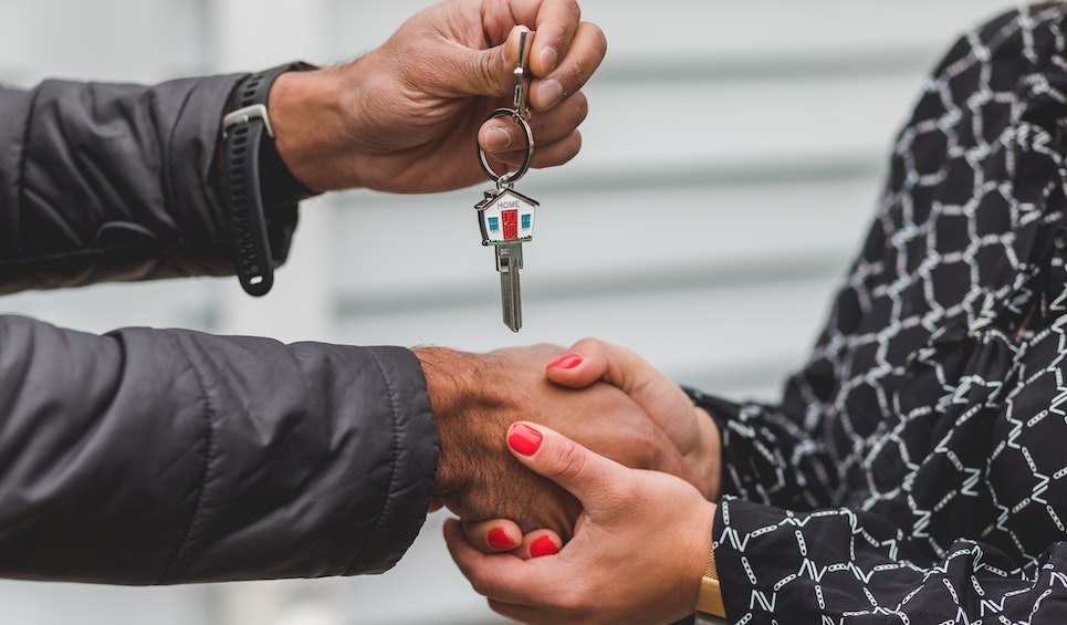 a man giving keys to a women expresses freehold property ownership in ajman