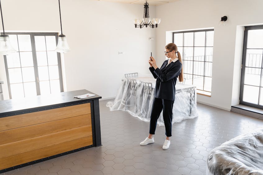 Real estate agent capturing photos of a modern unfurnished apartment to get property valuation